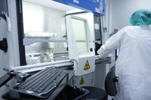 Bilden visar ett renrum i laboratoriemiljö. Med ergonomisk renrumsutrustning blir arbetet i renrummet mer ergonomiskt.